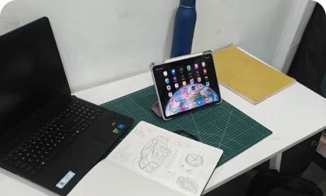 Varun's desk with a laptop and a tablet open to a sketch