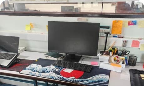 Vinayak's desk with dual monitors and sticky notes