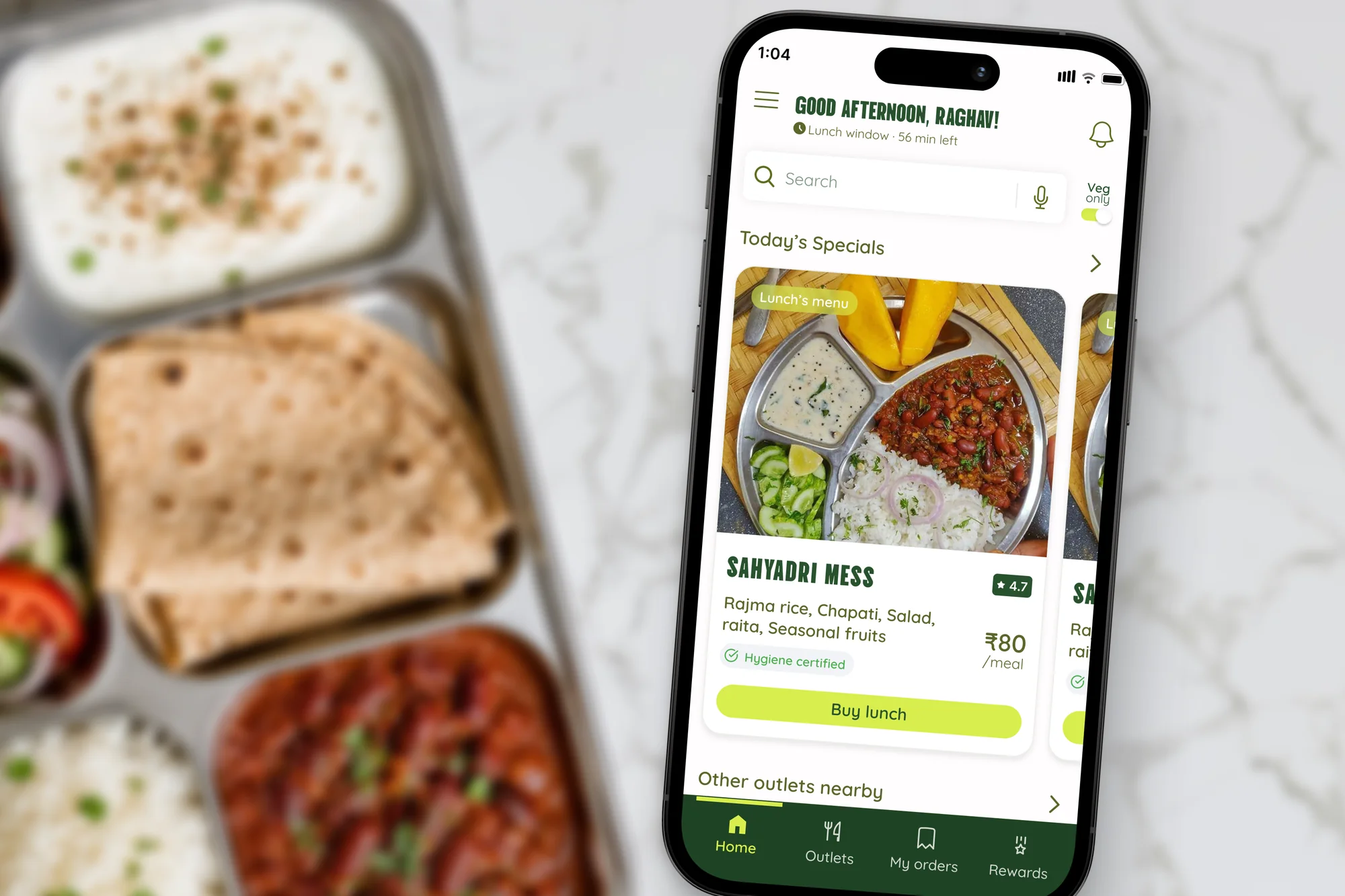 Phone showing a campus mess-ordering app over a tray of Indian food
